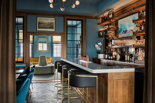The most hands-on part of the inn’s facelift happened in the bar and adjacent lounge area, where the front desk was removed and the bar was elongated. A new bar-back was constructed out of wood shelving and supported by copper piping. 