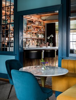 In the lounge, banquettes are upholstered in Lee Jofa’s Saranac Cord fabric in gold. 
