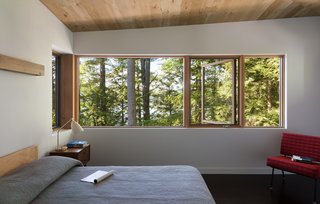 Above the bed, a custom wood valence acts as an indirect source of light that washes the wall in an ambient glow. 