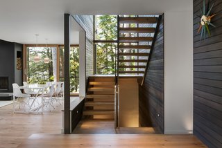 The exterior’s dark cedar siding was extended into the stairwell to connect the indoors and outdoors. 