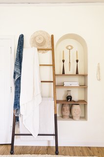 One of Zee's favorite nooks in the apartment, this alcove holds many of her treasured pieces, including the eye wall hanging by Heather Levine Ceramics.