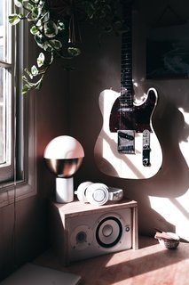 Zee's partner, musician Antrom Kury, works at a mini studio by the window.