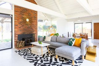 Encarnacion's living room is warm and cozy, with floor cushions under the table for extra seating. "One of my favorite pieces in the house is this brass table that is in the living room," she tells us. "When our diffuser is on it, it looks like a person doing Warrior 2 pose."