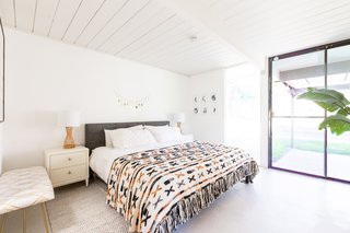 Moons adorn the walls of the airy bedroom, along with soothing hues for bedtime bliss.