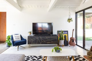 The living room exudes a bit of glam with jewel tones and gilded details. 