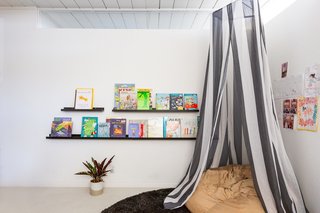 In 8-year-old Olivia's room, minimalist bookshelves and a comfy hideaway make for the perfect retreat.