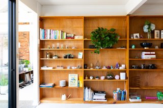 The bookshelf across from the breakfast nook holds favorite books, crystals, plants, and vintage cameras. 