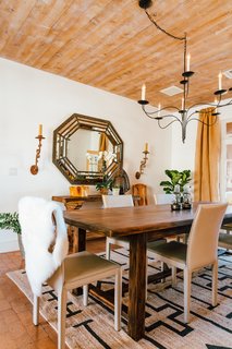 Young took cues from the home's architecture to refine the space while filling it with fresh decor. The floors are brick laid in sand, while large plank wood ceilings lie overhead. Adding to the neutral palette, the dining room is teeming with textures.
