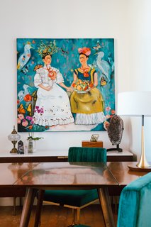 Young's home office exudes rustic glam with a painting of Frida Kahlo, vintage and contemporary lighting, polished and raw stones, and a midcentury table with plush chairs.