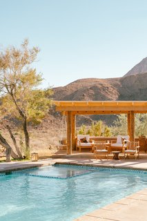 Despite the home's stylish interiors, Young is most drawn to what lies outdoors—a lounge for quiet moments and al fresco dining, a pool, an outdoor shower, the views, a 1972 VW Meyers Manx dune buggy, and a raised adobe platform with a teepee on the back veranda. 