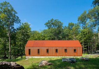 The Pond House has a standing-seam roof and wall panels made of Cor-Ten steel that throw the forest around it into relief.