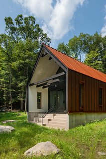 Glass doors and a patio with steps leading down to the pond create a seamless indoor/outdoor living experience.