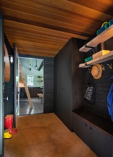 The mud room is swathed in the same inky palette as the exterior.