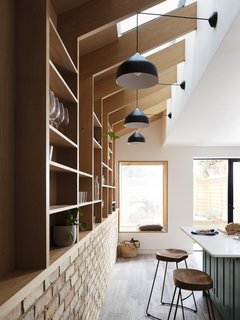 Amos Goldreich lighting and hairpin stools add a bold touch to the serene space. 