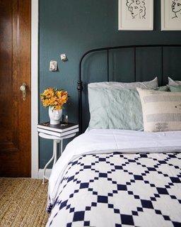 Moody hues penetrate the bedroom, which has deep emerald walls and a Crate & Barrel Mason Shadow bed in black. Francois brightened up the room with a Schoolhouse Winter + Summer cotton coverlet, a Pottery Barn Heather Chenille jute rug, and Matisse prints from Vivid Pictures via Etsy. 