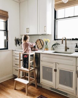 To allow for their two-year-old to be more involved in kitchen happenings, they built a toddler stool. The IKEA stool has a DIY topper frame to keep Sylvia from teetering off.