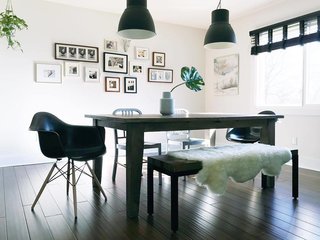 Reminiscent of Diane Keaton's inky abode, Conklin's moody dining room is furnished with Herman Miller chairs, IKEA pendant lights, and a Target bench. 