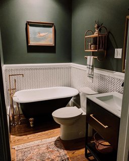 In this bathroom, the couple installed new flooring, swapped the shower stall for a tub, put in a new vanity, and updated the walls with tile and paint.