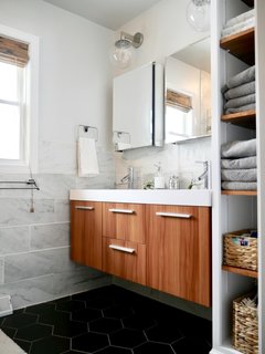 The couple turned a third bedroom into an en suite master bath by knocking down the walls between the two rooms, re-framing and building new walls, and adding plumbing and electrical.