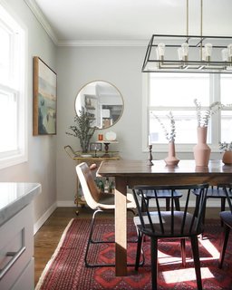 Old meets new in the dining room, tied together with a 1960s vintage Persian rug Laura found on eBay.