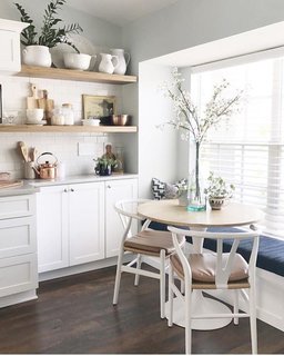 In the kitchen, they took down a wall and made an island instead of a peninsula, as well as added a breakfast nook. To add more storage and display some of their more beautiful wares, they made wood shelves with classic white subway tile above the breakfast nook. "Now, whoever is in the kitchen is never isolated from the rest of the family and it's made it so much easier for every day life and also entertaining."