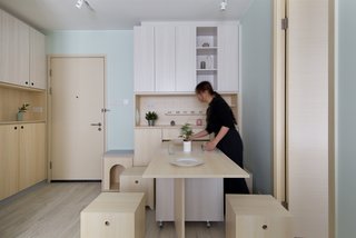 When more seating is required, the family can simply roll out more table space. The extra seating comes out from under the bird cabinet in the living room.