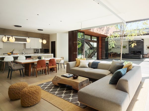 A Dellarobia Sectional offers comfy seating in the casual living room with a coffee table by Buka Design + Hardwoods.