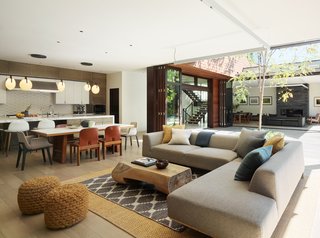 A coffee table by Buka Design + Hardwoods and a neutral Dellarobia sectional in the living room promote an earthy color and material palette.