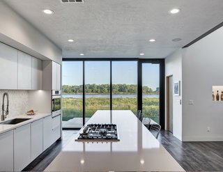 Although the front of the house has a neatly manicured lawn, the rear of the house looks out to views of the untamed prairie. The kitchen and its floor-to-ceiling glass doors were specifically designed to allow for views from the kitchen island out to the Missouri River. 