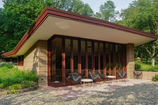 The cantilevered roofs and trim have been carefully painted and restored. Large windows blend the exterior terrace with the inside living space.