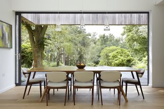 50 Modern Homes With Floor-to-Ceiling Windows - Photo 34 of 50 - London-based architecture and design studio Alma-nac designed House in the Woods, a contemporary home surrounded by pristine forest in England’s South Downs National Park to replace a decrepit, 1950s bungalow. The new 240-square-meter dwelling retains the former building’s simple gabled form and footprint, but offers greater flexibility with its ability to change from a single bedroom home to five bedrooms for large family gatherings. 