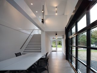 A Shipping Container Prefab Lab Is Built in Only 4 Hours - Photo 4 of 12 - Stairs lead up to a small loft-like office that overlooks the meeting room below.