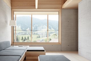 A Minimalist Home Is Built Into Steep Terrain in an Austrian Valley - Photo 5 of 13 - Large windows frame views of the rural Austrian valley.