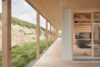 A Minimalist Home Is Built Into Steep Terrain in an Austrian Valley - Photo 4 of 13 - The second floor terrace steps directly out onto the hill. The slatted spruce screens provide privacy, while also allowing natural light to filter indoors.