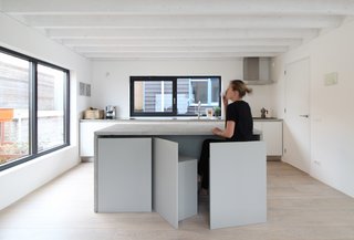 An Architect Creates a Two-Level Houseboat For His Family on a Tight Budget - Photo 1 of 10 - Built-in storage and space-saving furnishings—such as seating that stores flush beneath a table—reduce visual clutter without compromising functionality.