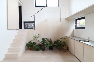 An Architect Creates a Two-Level Houseboat For His Family on a Tight Budget - Photo 2 of 10 - A flexible, double-height space located on one end of the home is used as an office during the week. However, it can also be converted into a guest-room on weekends. 