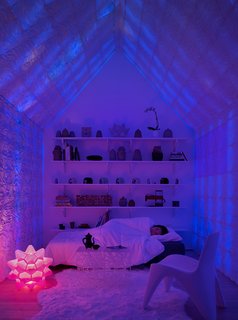 At night, the Chroma Curl walls are backlit with color-changing LEDs for a luminous effect. The 3D-printed pink Picoroco lamp serves as a night lamp.