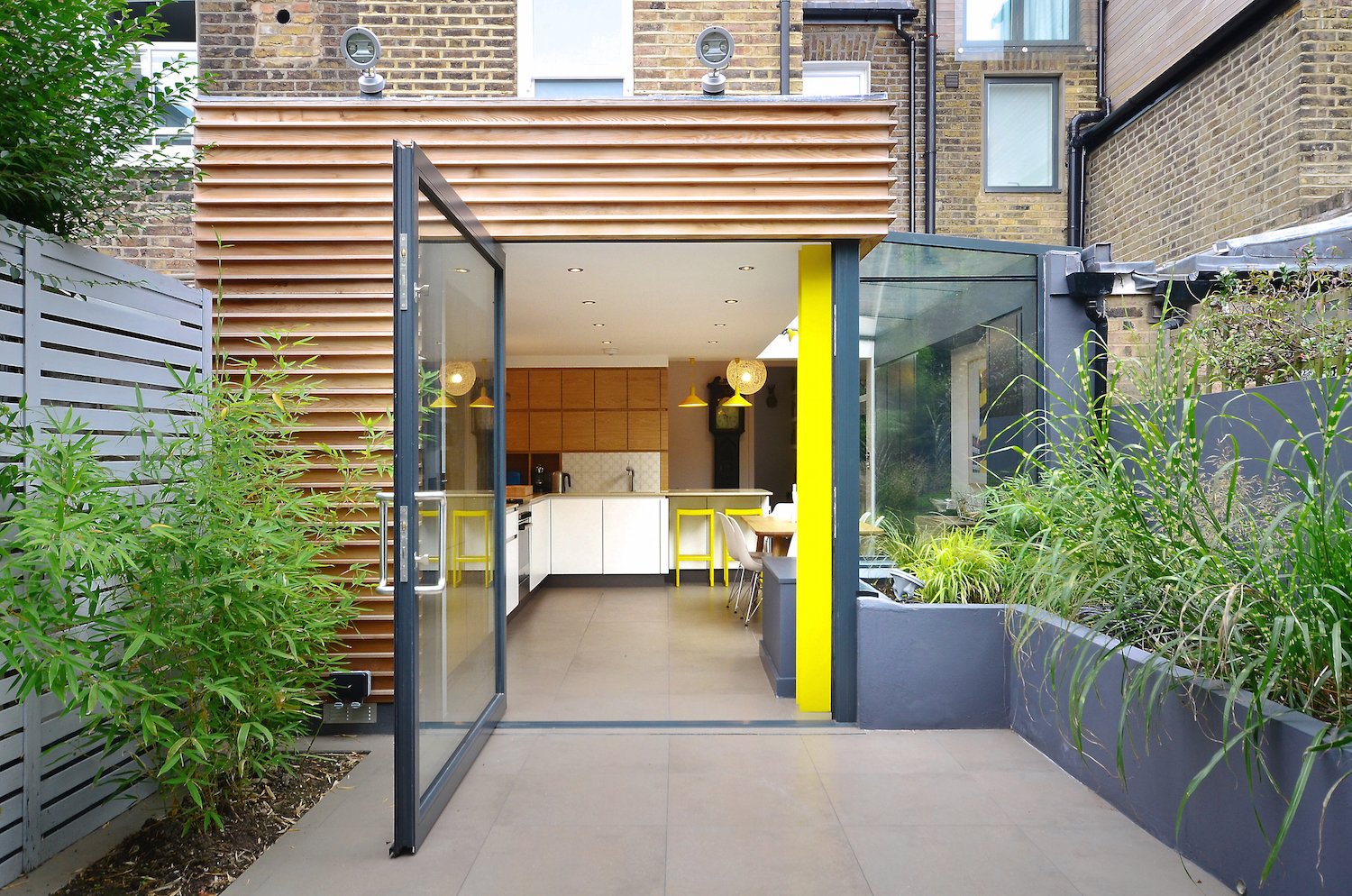The kitchen's structural pillar was painted a vibrant yellow, a shade that's echoed in the furnishings.