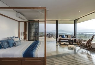 The master bedroom opens up to a small terrace through full-height glazed sliding doors.