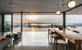 The open-plan dining and living area flow seamlessly into the outdoor terracotta terrace.