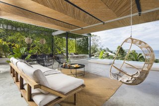 A hanging rattan chair and Acapulco chairs add a breezy, laid-back vibe to the lounge.