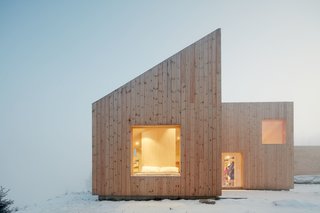 Planning regulations required a gable roof, which the architects split into four shed roofs carefully designed to respond to heavy snow and meet spatial and aesthetic wishes.