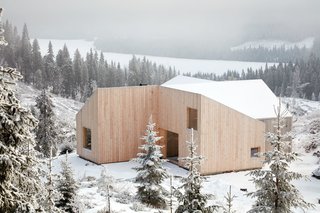 Planning regulations required a gable roof, which the architects split into four shed roofs carefully designed to respond to heavy snow shed and meet spatial and aesthetic wishes.