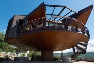 The house is accessed via an external staircase built of wood and wrought iron.