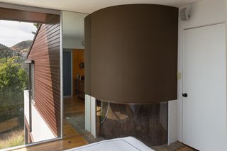 A curved fireplace anchors a corner of the master bedroom.
