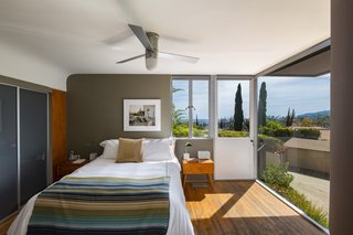 A floor-to-ceiling window in the master bedroom brings the outdoors in.