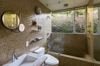 Colored tiles line the bathroom, which is set deep into the slope.