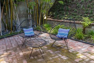 A bamboo grove provides privacy to the brick-paved patio in the backyard.