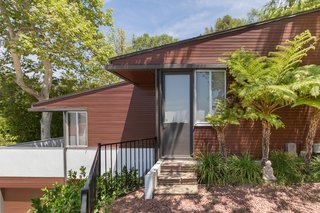 Previous owners had painted the redwood siding pink, so Hay—unable to strip the paint out of the wood—repainted the exterior a dark reddish-brown in an imitation of the siding’s original color and texture.