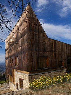 The band of glazing separates the timber cladding from the stone base.